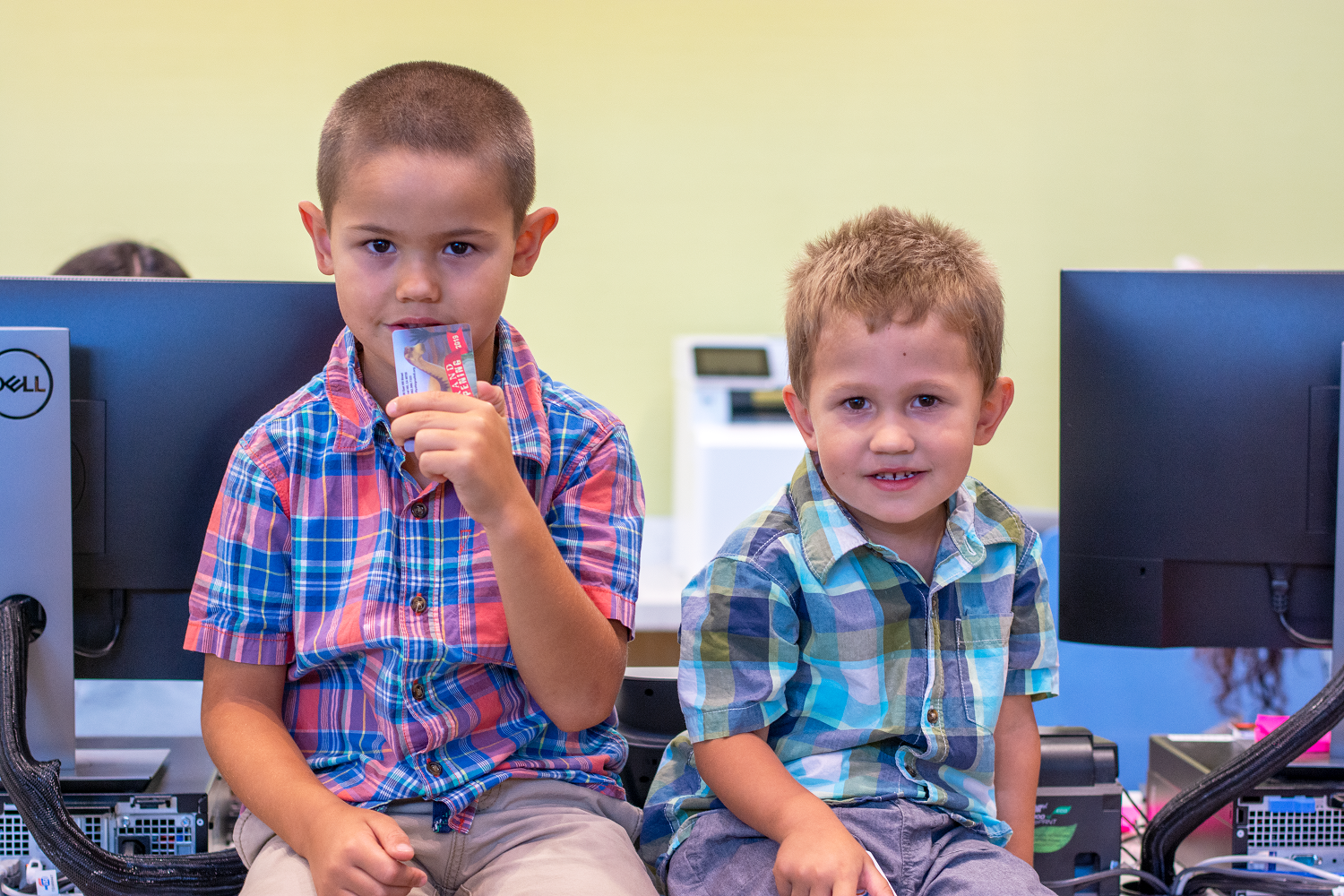 Two young boys sitting on a counter.