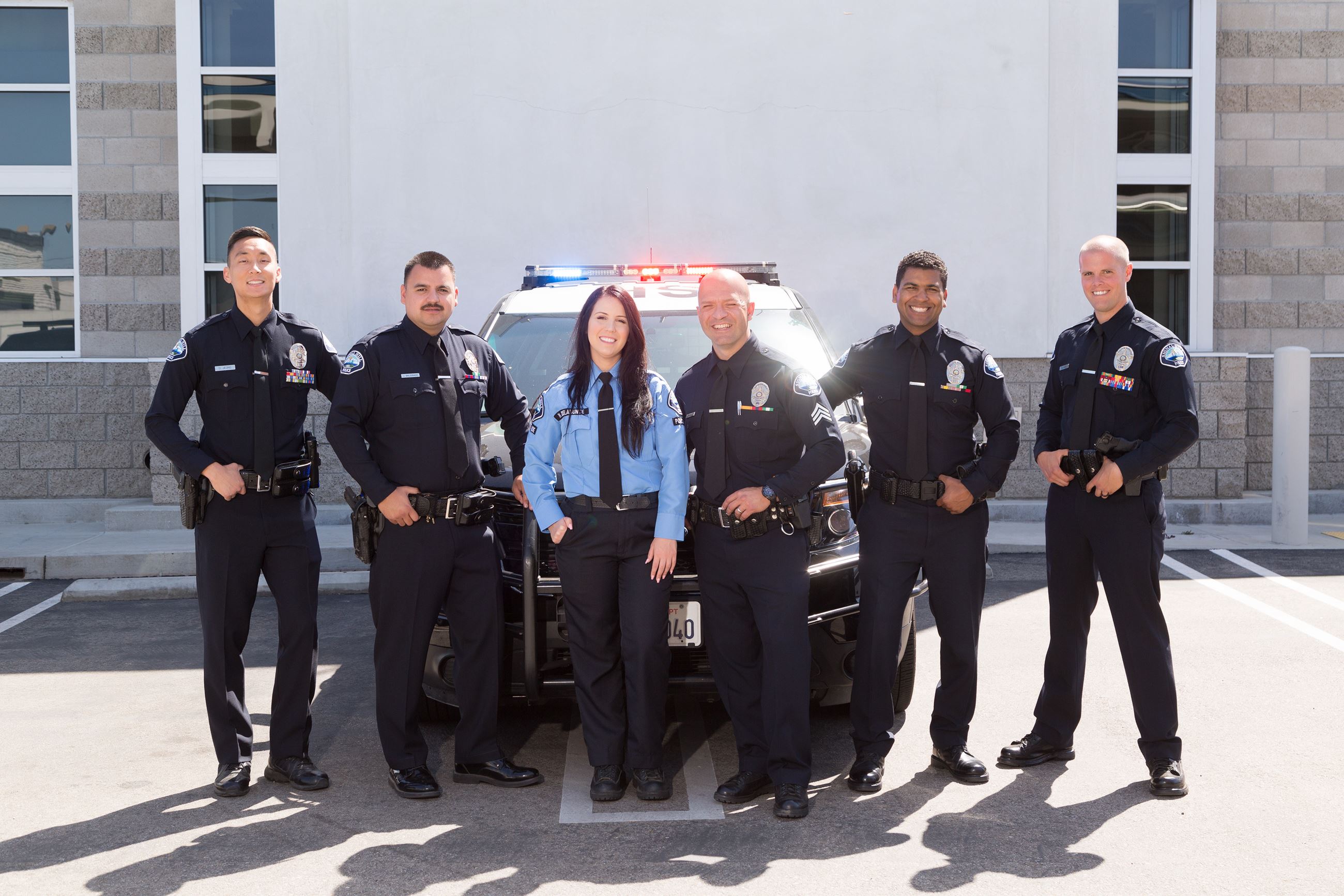 Police Officers Smiling in front of a police car