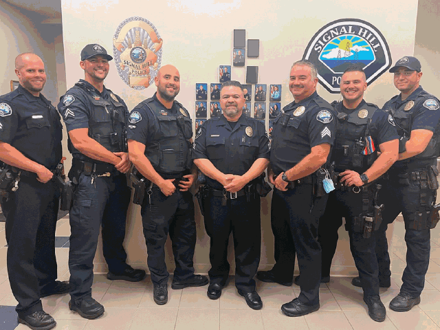 A group of police officers lined up and smiling