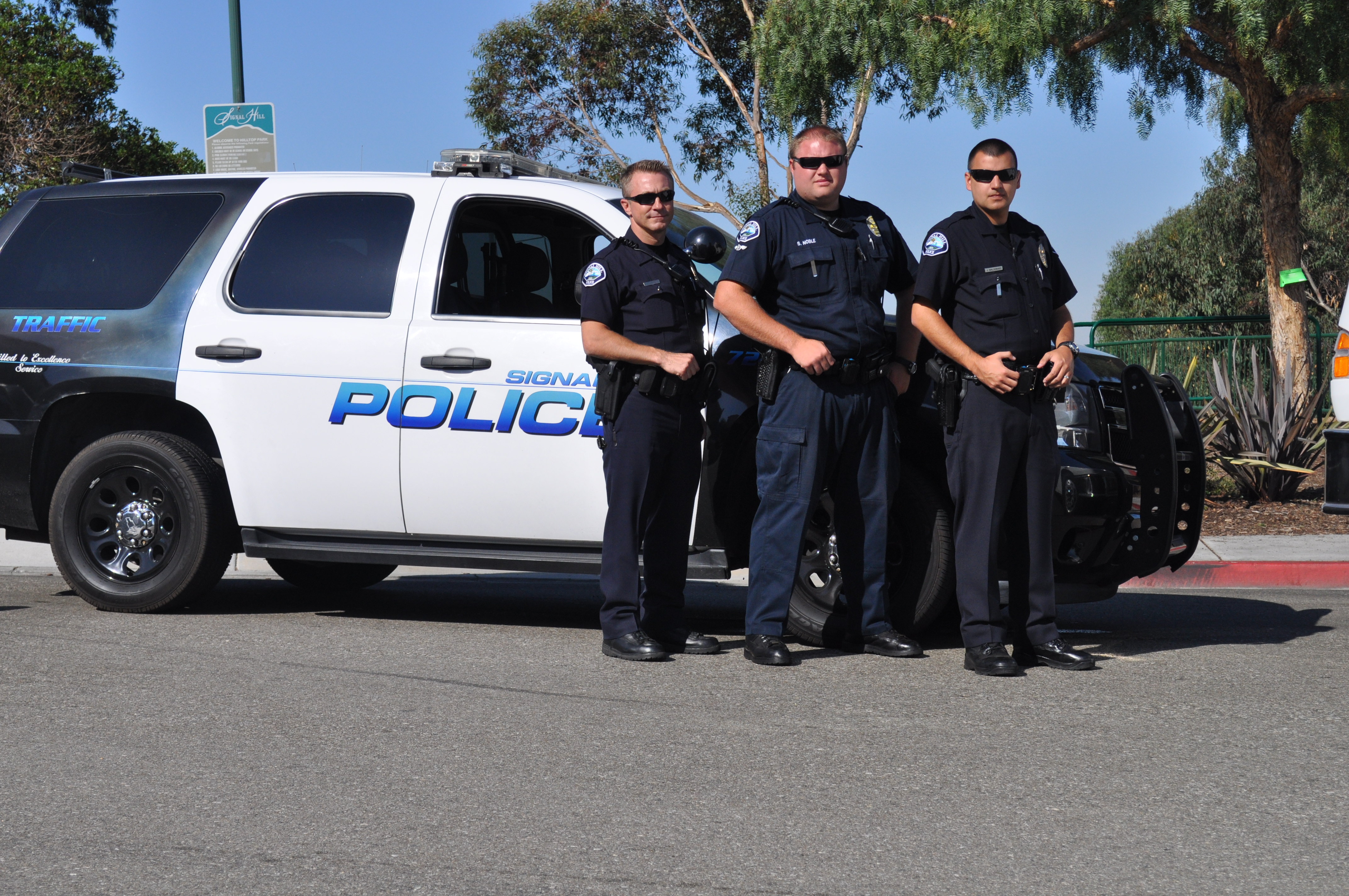 Officers standing by a police car